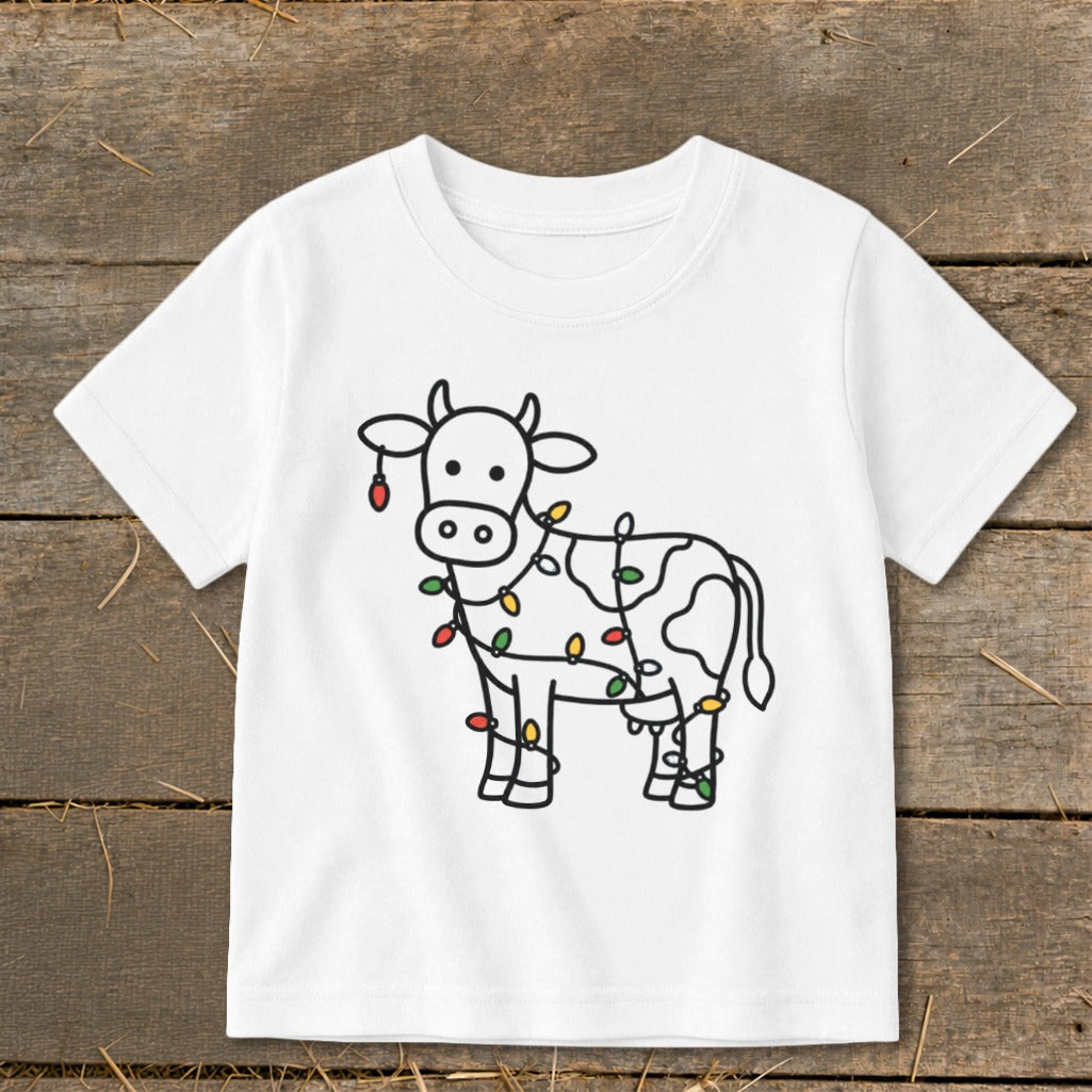 White t-shirt with cartoon cow wrapped in colorful Christmas lights.