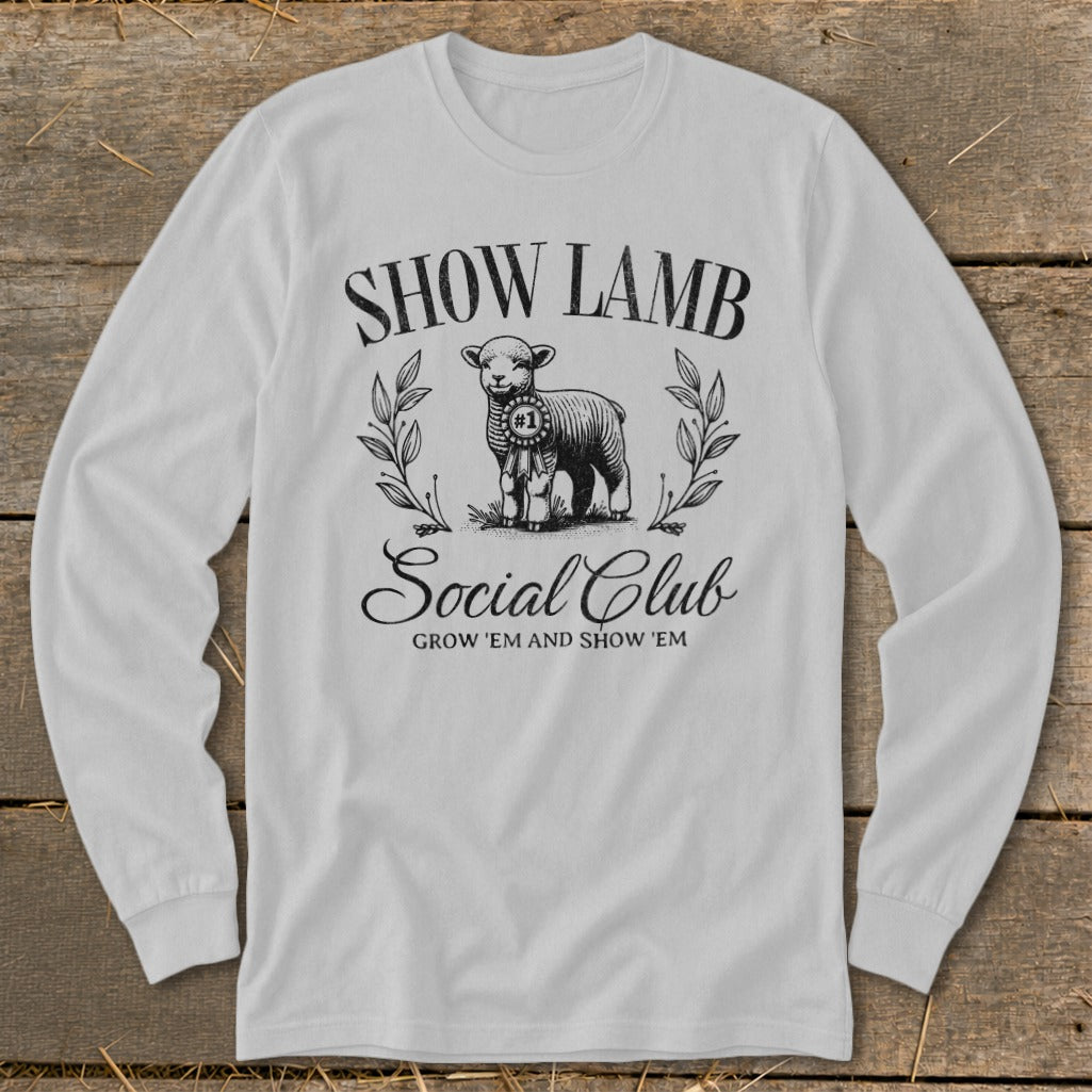 White long-sleeve shirt with "Show Lamb Social Club" and a ribbon-wearing lamb graphic.
