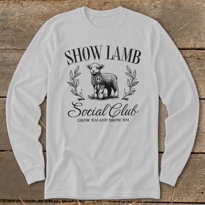 White long-sleeve shirt with "Show Lamb Social Club" and a ribbon-wearing lamb graphic.