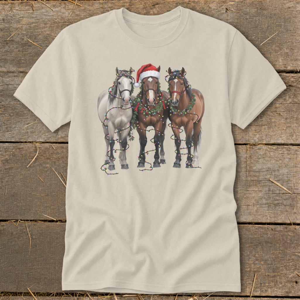 Three horses, one with a Santa hat, decorated with Christmas lights and garland.