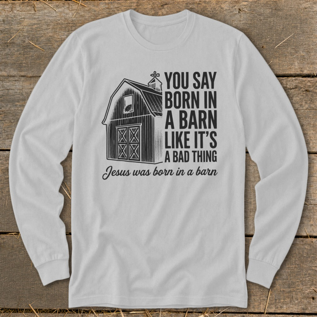 White long-sleeve shirt with barn graphic and text "You Say Born in a Barn Like It's A Bad Thing Jesus was born in a barn".