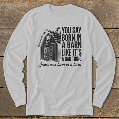 White long-sleeve shirt with barn graphic and text "You Say Born in a Barn Like It's A Bad Thing Jesus was born in a barn".