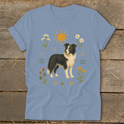 Light blue t-shirt with illustration of a Border Collie surrounded by flowers and a sun.