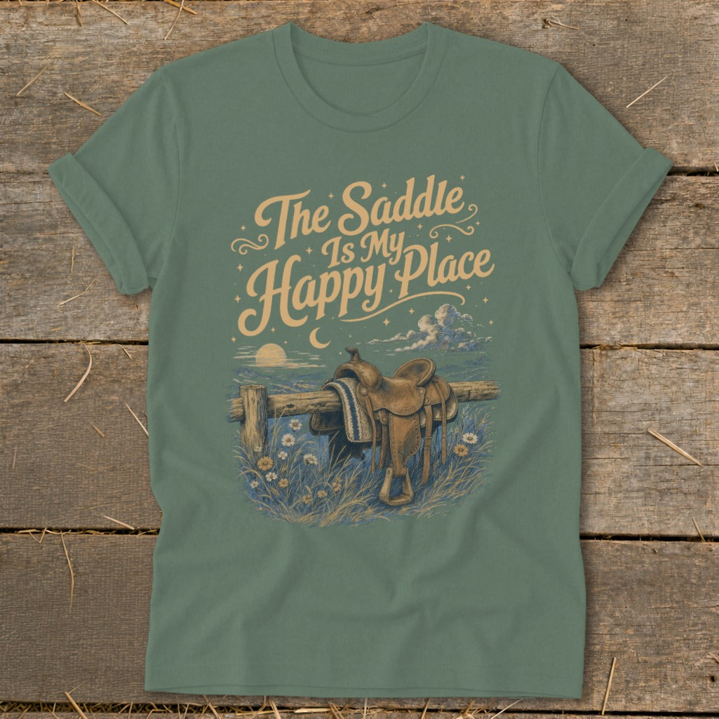 Green t-shirt with text "The Saddle Is My Happy Place" and a saddle on a fence.