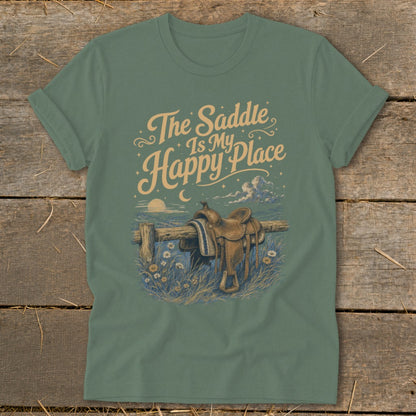 Green t-shirt with text "The Saddle Is My Happy Place" and a saddle on a fence.