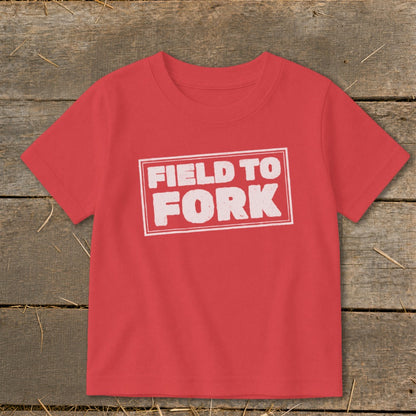 A red short-sleeve t-shirt with the text FIELD TO FORK printed in a white distressed rectangle.