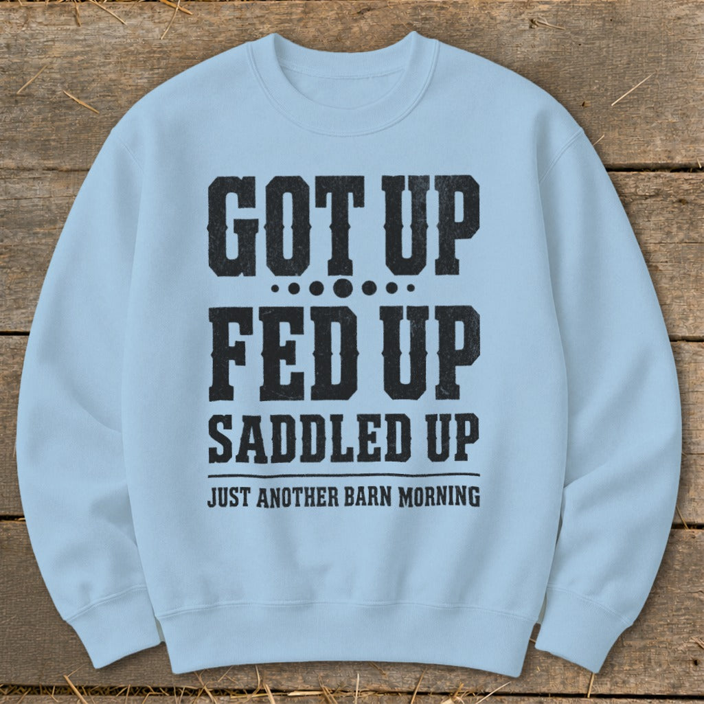 Light blue sweatshirt with black text: "GOT UP FED UP SADDLED UP JUST ANOTHER BARN MORNING".