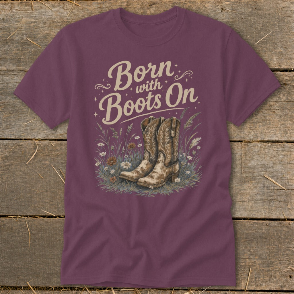 Burgundy t-shirt with "Born with Boots On" text and cowboy boots in wildflowers.