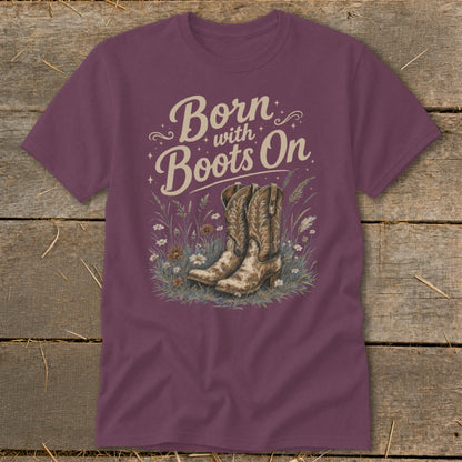 Burgundy t-shirt with "Born with Boots On" text and cowboy boots in wildflowers.