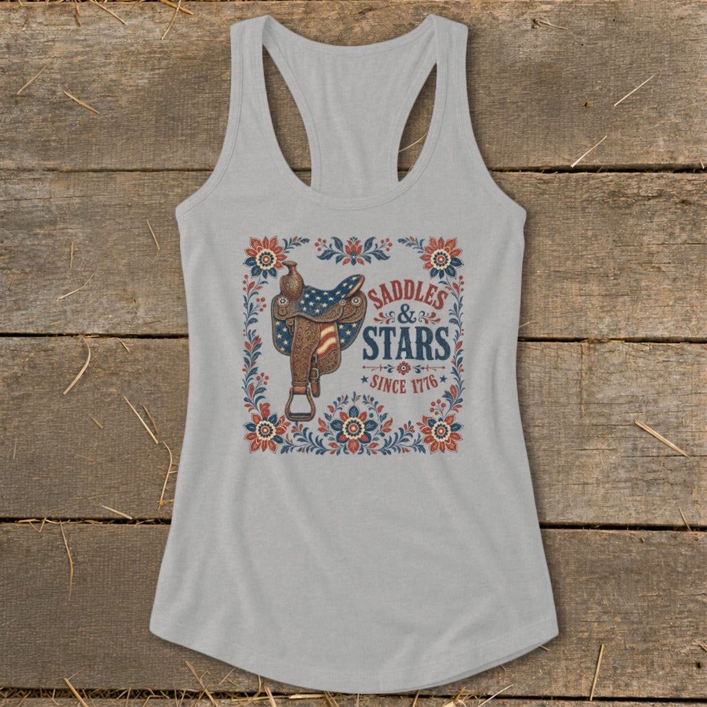 Grey tank top with a western saddle design featuring American flag stars and text "Saddles & Stars Since 1776".