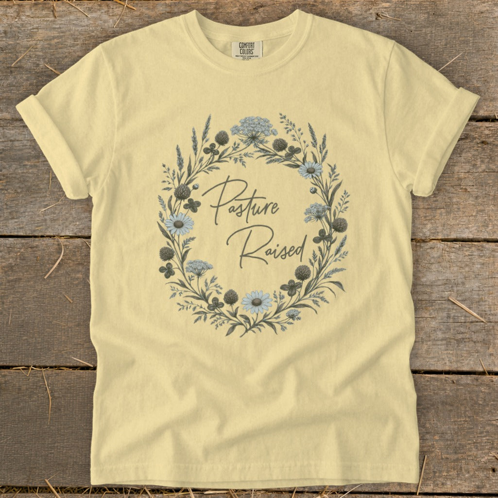 Light yellow t-shirt with a floral wreath and "Pasture Raised" text.
