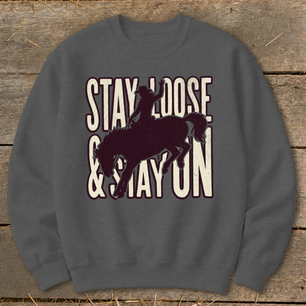 Dark grey sweatshirt with "Stay Loose & Stay On" text and bucking bronco graphic.