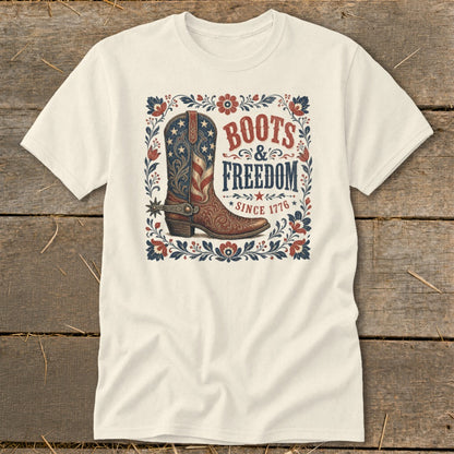Cream t-shirt with patriotic cowboy boot graphic and text "Boots & Freedom Since 1776".
