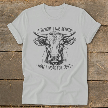 T-shirt with sketch of a cow's head and text "I thought I was retired - Now I work for cows".