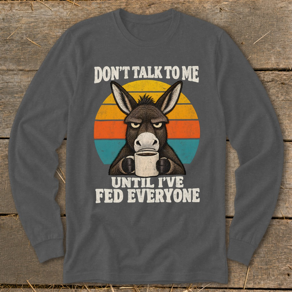 A dark gray long-sleeve t-shirt with a graphic of a grumpy donkey holding a coffee mug.