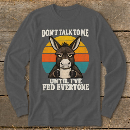 A dark gray long-sleeve t-shirt with a graphic of a grumpy donkey holding a coffee mug.