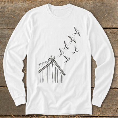 A white long-sleeve t-shirt features a black line drawing of swallows flying up from a barn roof.