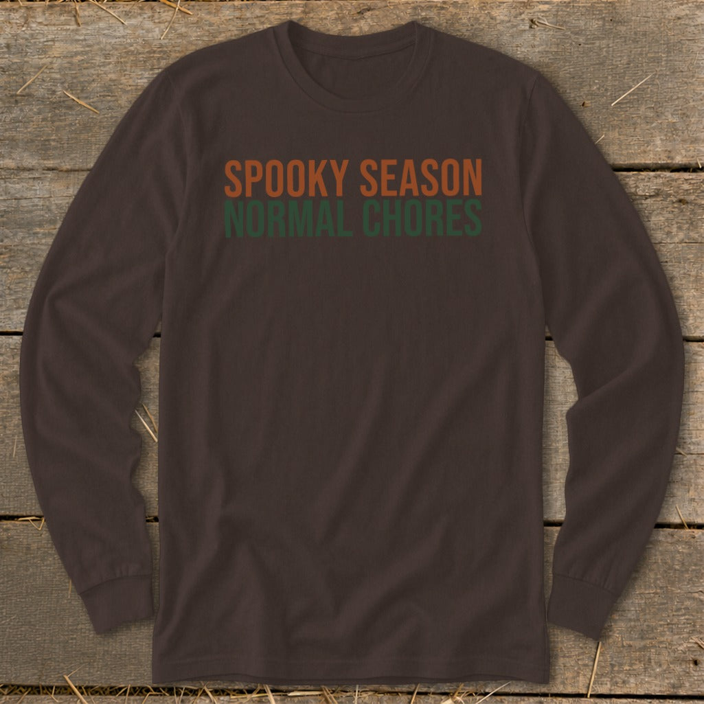 Brown long-sleeved shirt with text "Spooky Season Normal Chores" in orange and green.