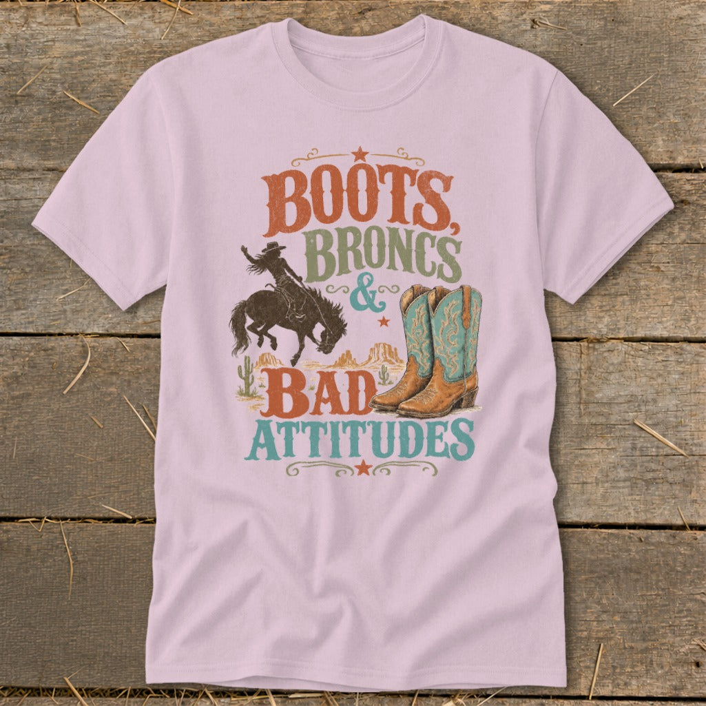 Pink t-shirt with distressed graphic: Boots, Broncs & Bad Attitudes.