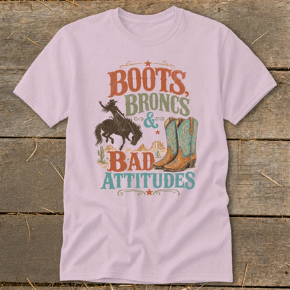 Pink t-shirt with distressed graphic: Boots, Broncs & Bad Attitudes.