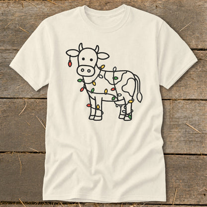 Cream t-shirt with a black outline drawing of a cow wrapped in colorful Christmas lights.