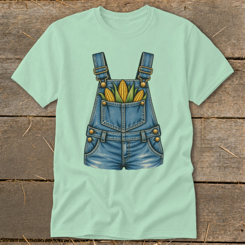 Mint green t-shirt with a graphic of denim overalls holding three ears of corn.