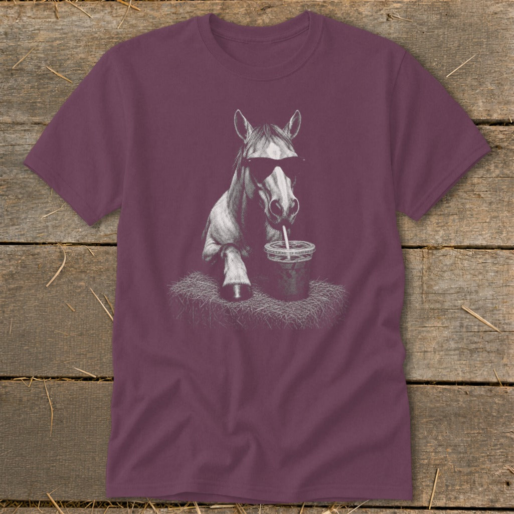 Horse wearing sunglasses drinking from a cup on a maroon t-shirt.