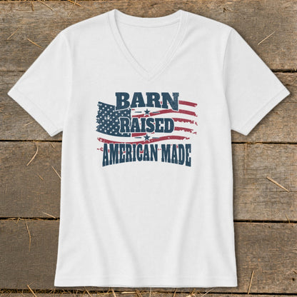 White V-neck t-shirt with distressed American flag graphic and text "BARN RAISED AMERICAN MADE."