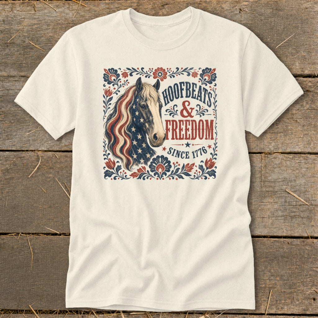 Cream t-shirt with distressed American flag horse and "Hoofbeats & Freedom Since 1776" text.