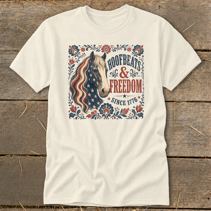 Cream t-shirt with distressed American flag horse and "Hoofbeats & Freedom Since 1776" text.