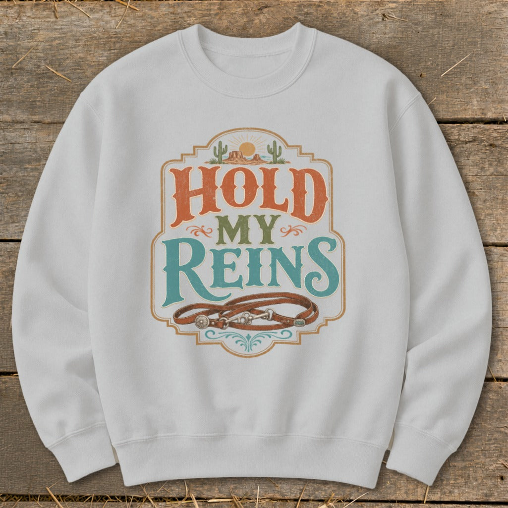 White sweatshirt with "Hold My Reins" graphic and leather reins.