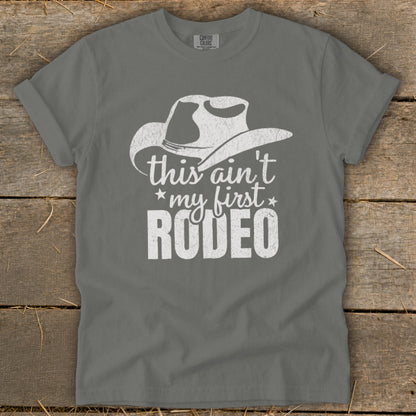 Gray t-shirt with distressed white cowboy hat and text "this ain't my first RODEO".