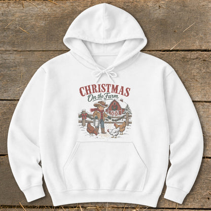 White hoodie with "Christmas On the Farm" graphic of a child feeding chickens.