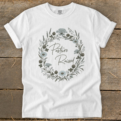 White t-shirt with "Pasture Raised" text in a floral wreath design.