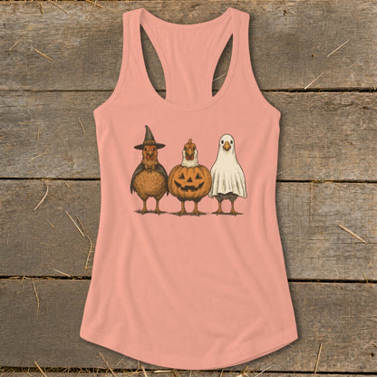 Three chickens dressed for Halloween as a witch, pumpkin, and ghost.