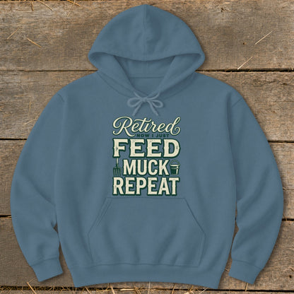 Blue hoodie with text "Retired Now I Just Feed Muck Repeat" and farm icons.