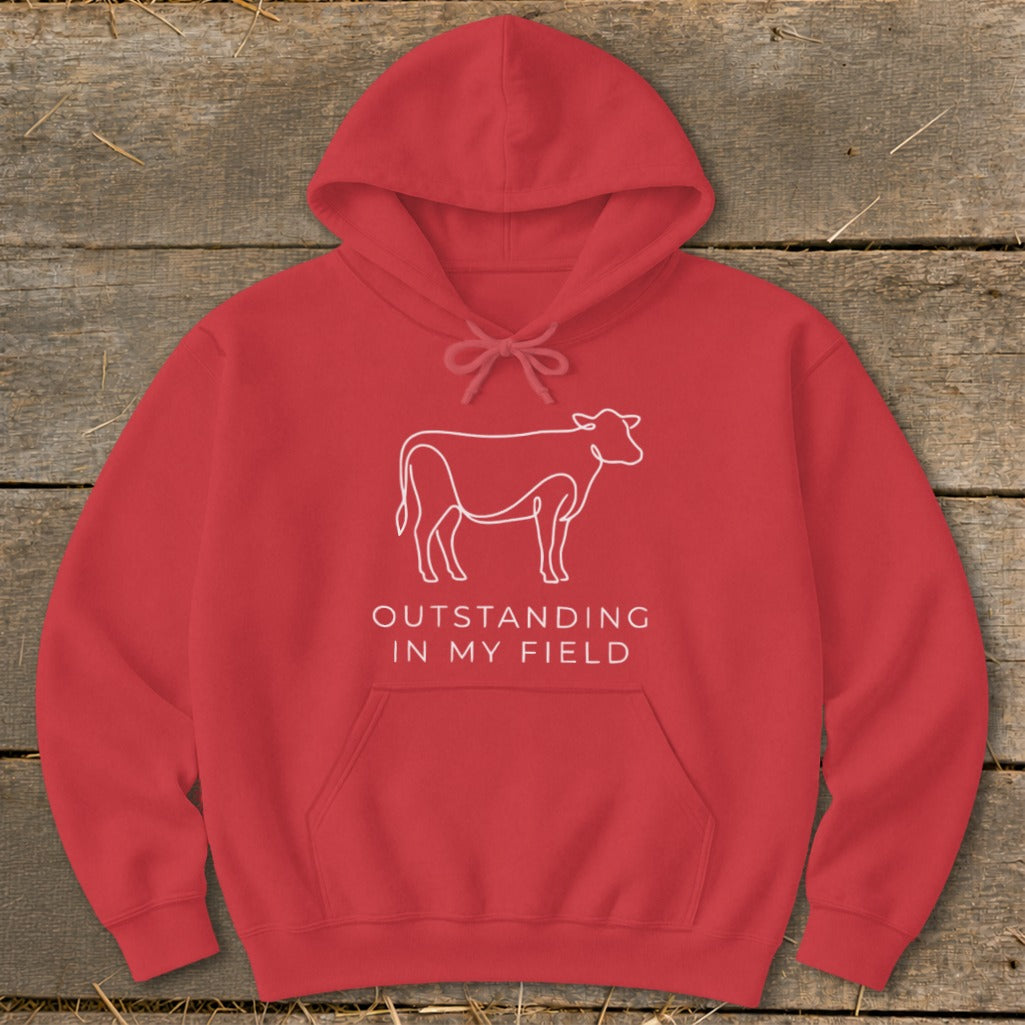 Red hoodie with a white line drawing of a cow and text that says "OUTSTANDING IN MY FIELD".