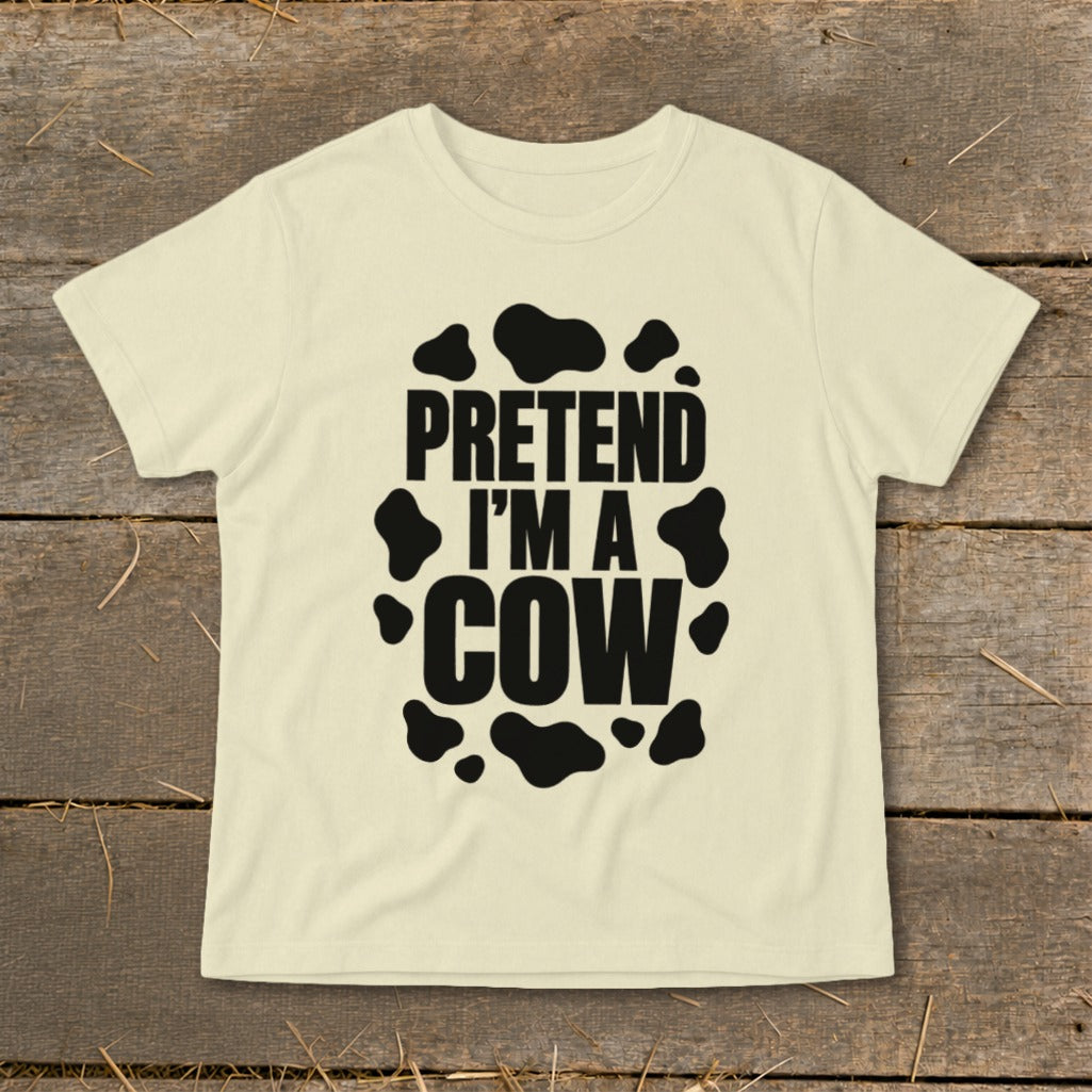 Cream t-shirt with black text "PRETEND I'M A COW" and cow spots.