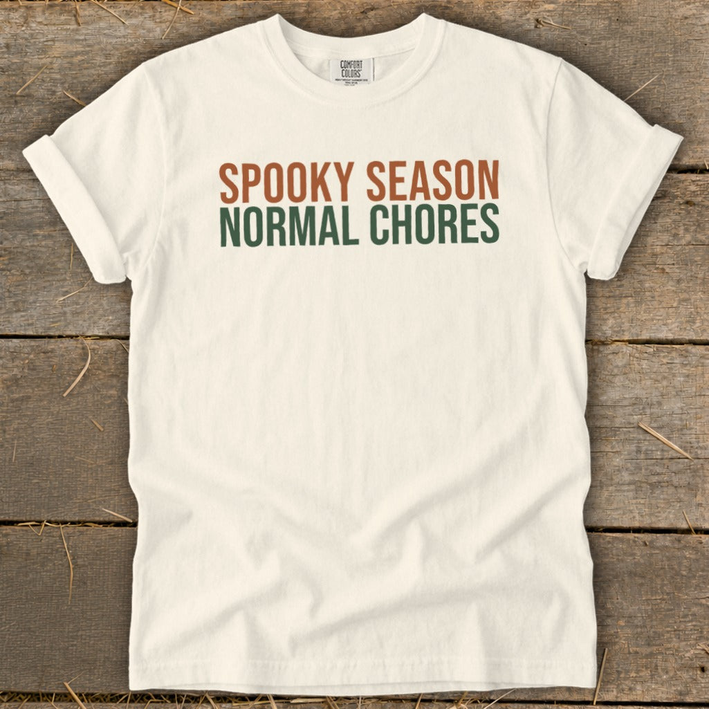 Cream t-shirt with "SPOOKY SEASON NORMAL CHORES" text in brown and green.