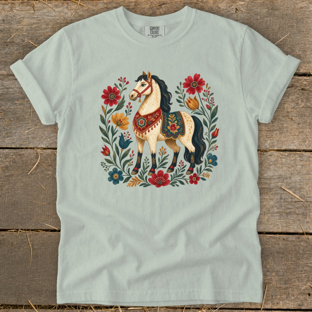 Light blue t-shirt featuring a cream horse surrounded by colorful floral motifs.