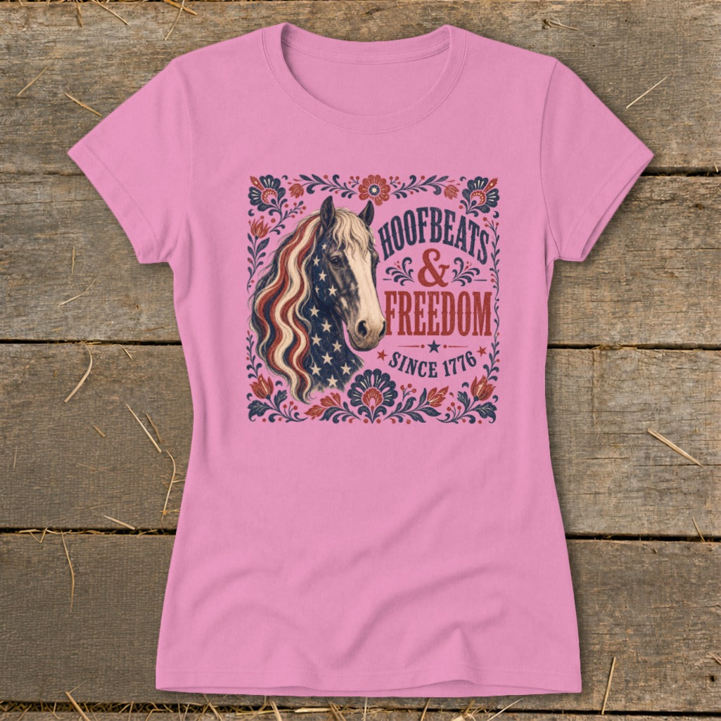 Pink t-shirt with a horse wearing an American flag mane, text "Hoofbeats & Freedom Since 1776".