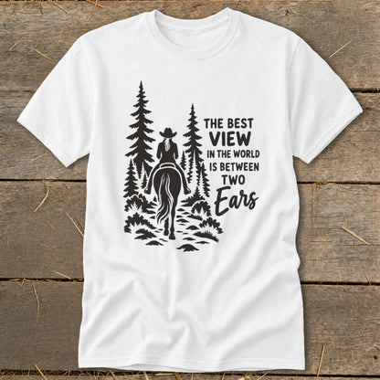 White t-shirt featuring a black graphic of a horseback rider in the forest with text that reads, "The best view in the world is between two ears."