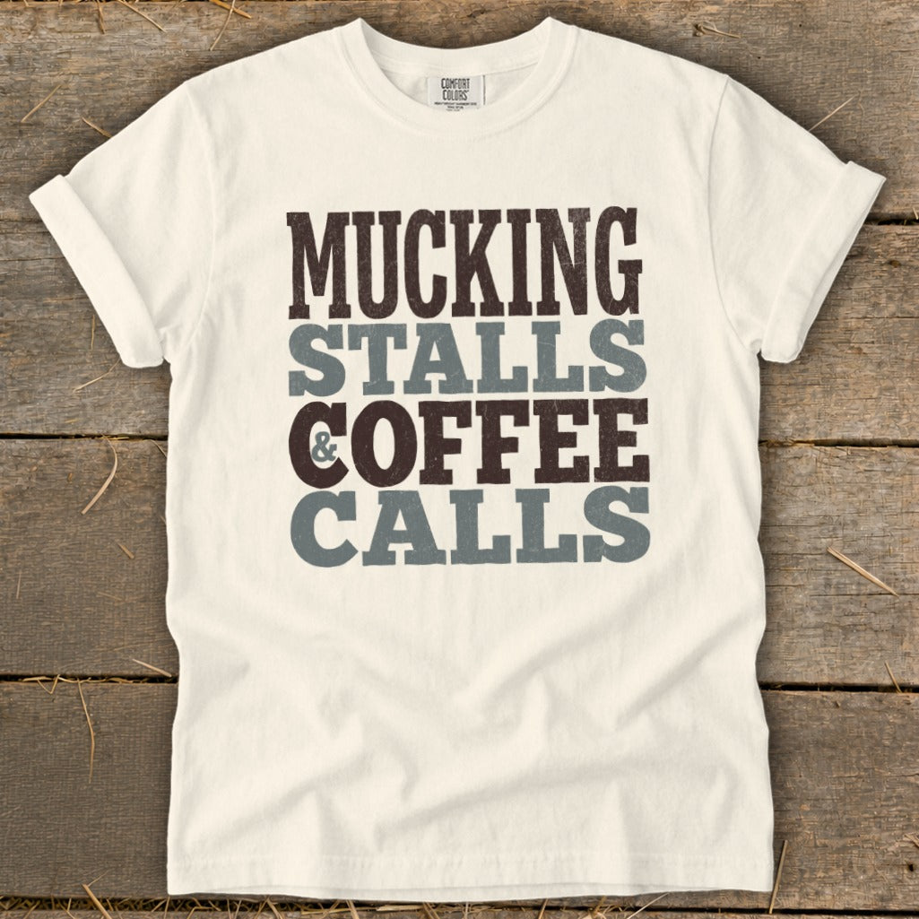 White t-shirt with "MUCKING STALLS & COFFEE CALLS" text in brown and gray.