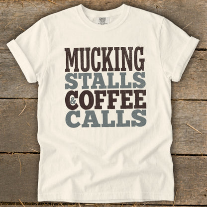 White t-shirt with "MUCKING STALLS & COFFEE CALLS" text in brown and gray.