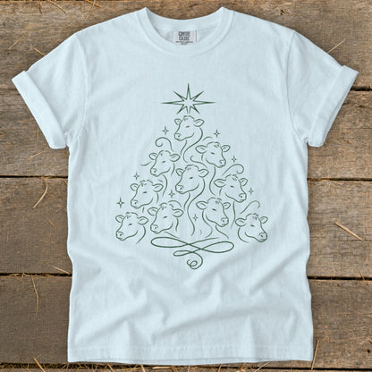 White t-shirt with green outline of cows forming a Christmas tree with a star.