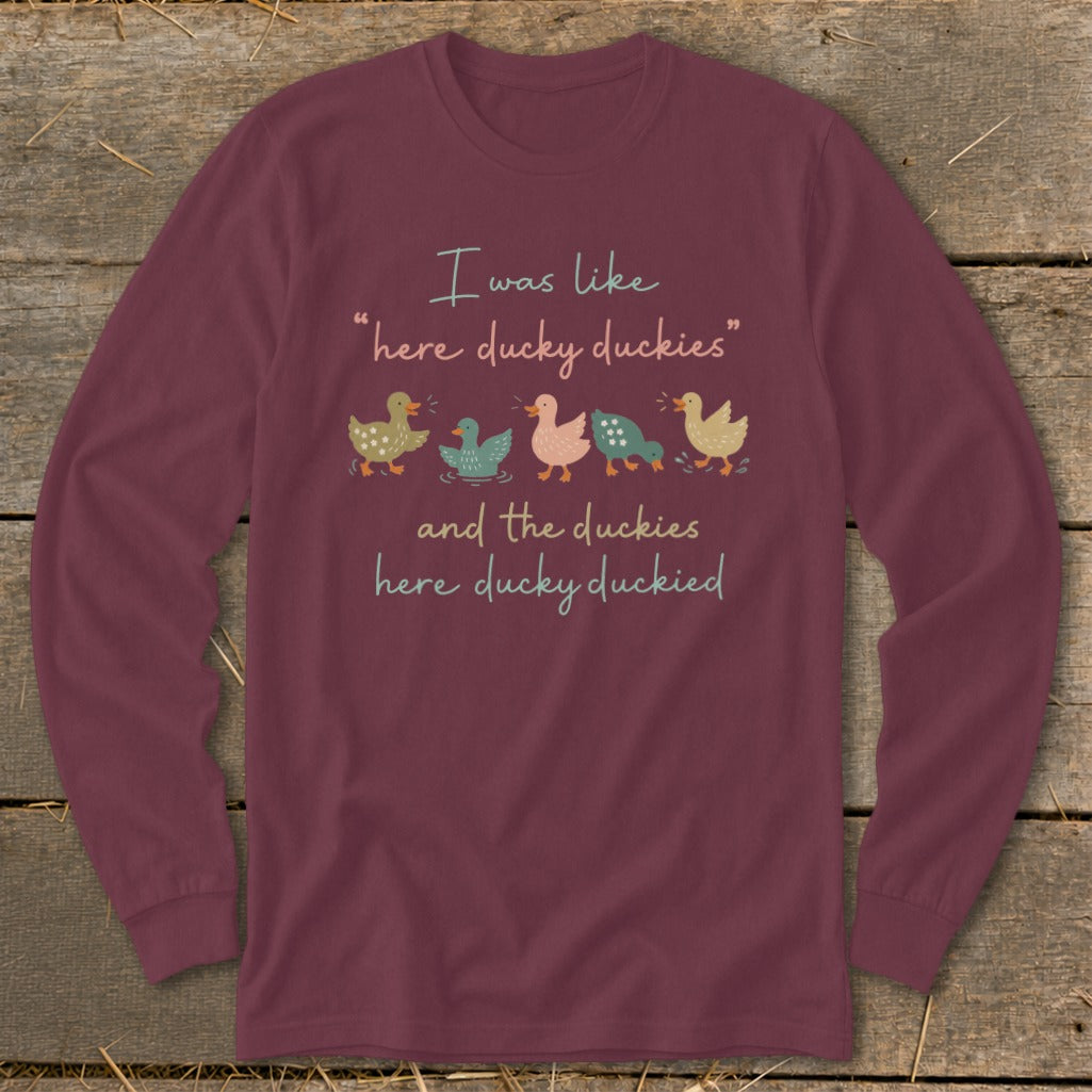 Maroon long sleeve shirt with ducks and text: "I was like 'here ducky duckies' and the duckies here ducky duckied".