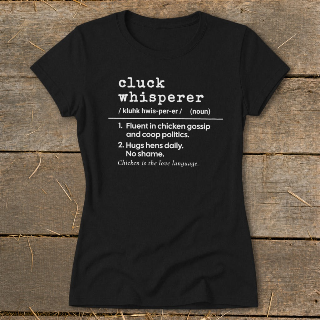 Black t-shirt with "cluck whisperer" definition: fluent in chicken gossip, hugs hens daily.