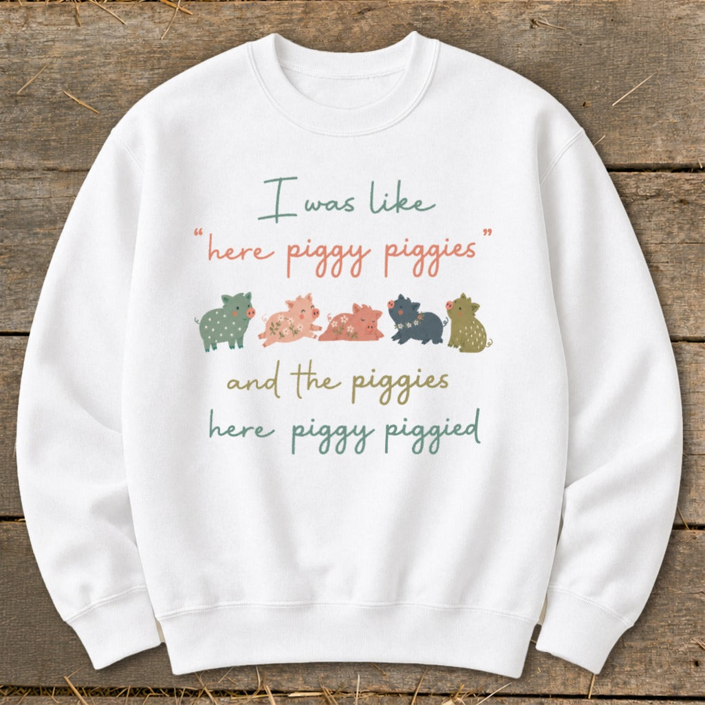 White sweatshirt with cartoon pigs and text: "I was like 'here piggy piggies' and the piggies here piggy piggied."