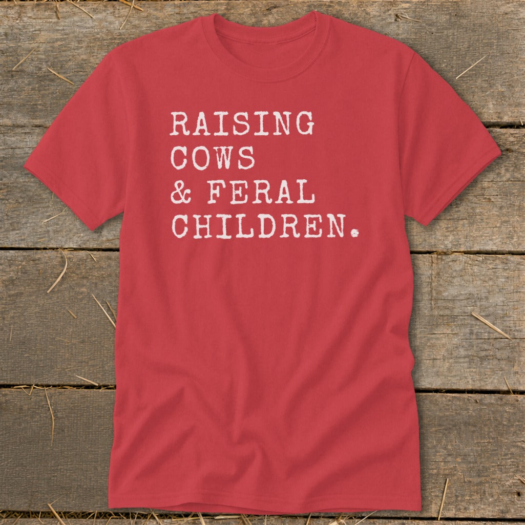 Red t-shirt with white text reading "RAISING COWS & FERAL CHILDREN."