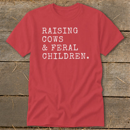 Red t-shirt with white text reading "RAISING COWS & FERAL CHILDREN."